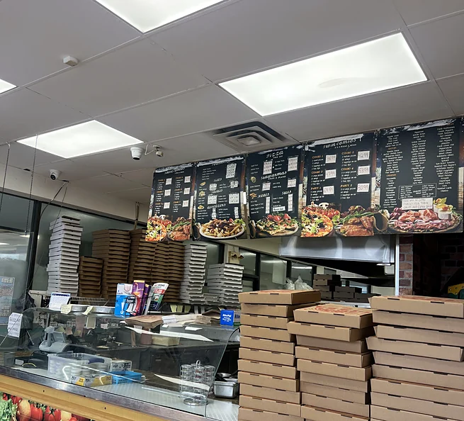 Pizza boxes stacked behind the counter at Lava Pizza & Wings