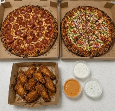 Two pizzas, a box of chicken wings and dips for a party order