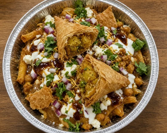 Samosa chaat poutine with broken samosas, chickpeas, yogurt, tamarind chutney and cilantro